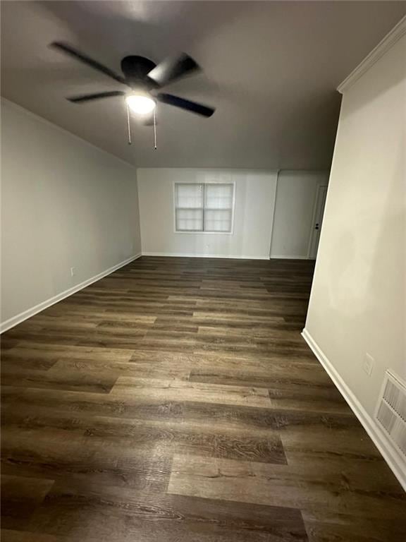 unfurnished room featuring dark wood-style floors, ceiling fan, visible vents, and baseboards