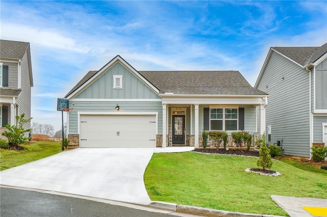 craftsman inspired home featuring board and batten siding, a front yard, stone siding, and a garage