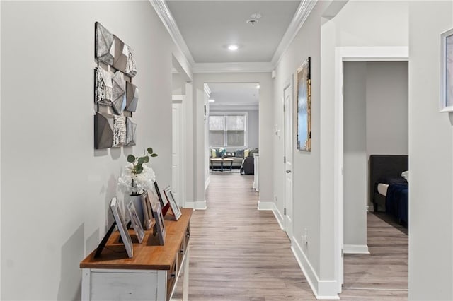 hallway with ornamental molding, light wood-type flooring, recessed lighting, and baseboards