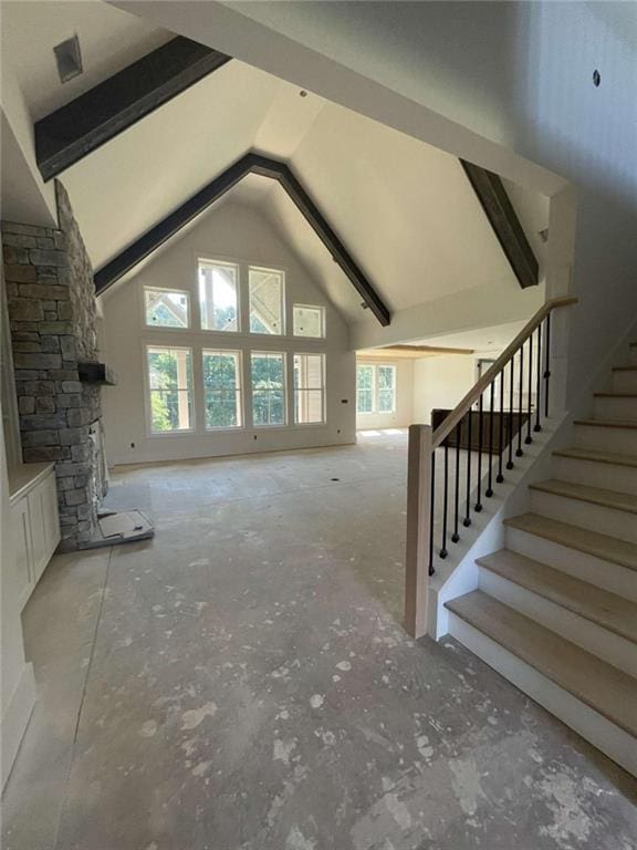 1210 Askew Trl, Greensboro, GA 30642 - unfurnished living room with stairway, a stone fireplace, beamed ceiling, and high vaulted ceiling