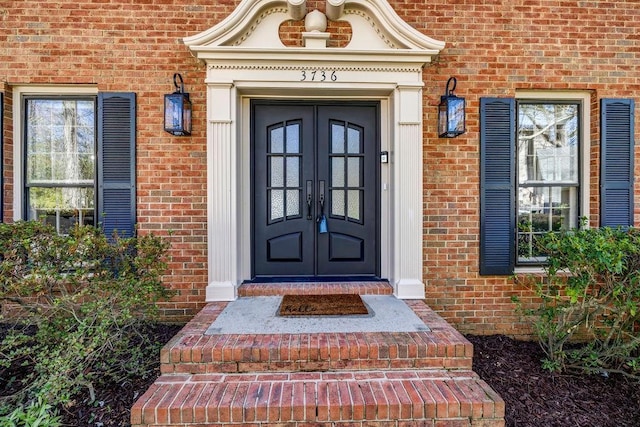 view of exterior entry with french doors and brick siding