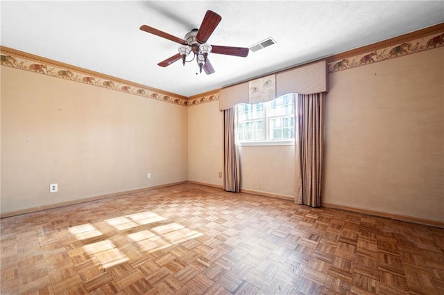 empty room featuring ceiling fan, parquet flooring, and a textured ceiling