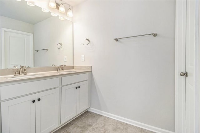 full bathroom with tile patterned floors, double vanity, a sink, and baseboards