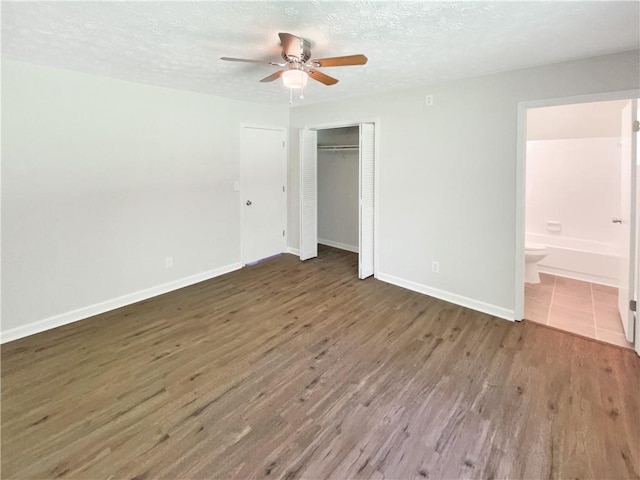 2492 Wild Rose Cir, Lawrenceville, GA 30044 - unfurnished bedroom featuring wood finished floors, a textured ceiling, baseboards, a closet, and ceiling fan
