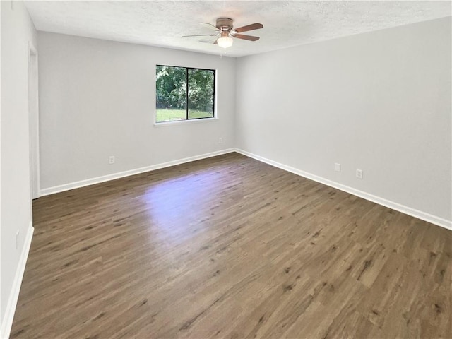 2492 Wild Rose Cir, Lawrenceville, GA 30044 - empty room with ceiling fan, dark wood-style floors, a textured ceiling, and baseboards