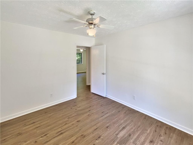 2492 Wild Rose Cir, Lawrenceville, GA 30044 - unfurnished room with wood finished floors, baseboards, a ceiling fan, and a textured ceiling