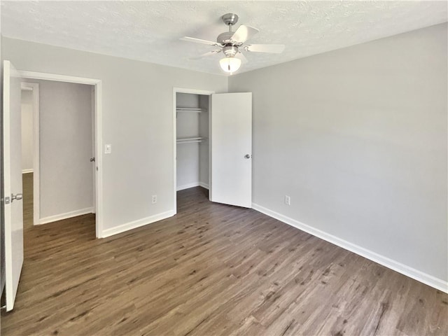 2492 Wild Rose Cir, Lawrenceville, GA 30044 - unfurnished bedroom featuring wood finished floors, baseboards, a closet, a textured ceiling, and ceiling fan