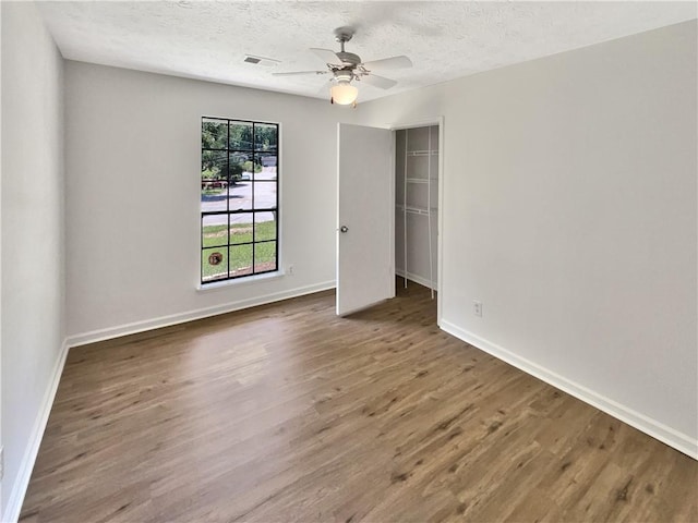 2492 Wild Rose Cir, Lawrenceville, GA 30044 - unfurnished bedroom featuring wood finished floors, baseboards, a textured ceiling, a closet, and a ceiling fan