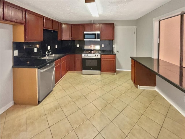 2492 Wild Rose Cir, Lawrenceville, GA 30044 - kitchen featuring appliances with stainless steel finishes, a sink, backsplash, dark countertops, and a textured ceiling