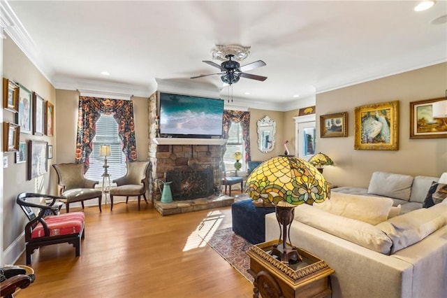 living room featuring crown molding, a stone fireplace, and wood-type flooring