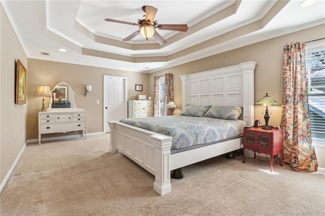 bedroom with light carpet, ornamental molding, a raised ceiling, and ceiling fan