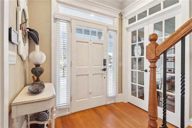 entryway with hardwood / wood-style flooring, ornamental molding, and plenty of natural light