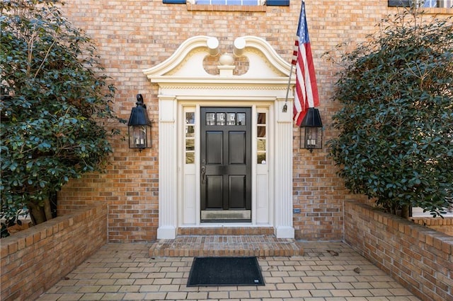 doorway to property with brick siding