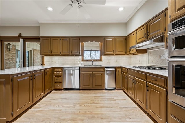 kitchen with stainless steel appliances, crown molding, under cabinet range hood, and a peninsula