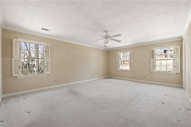 unfurnished room with baseboards, light colored carpet, visible vents, and crown molding