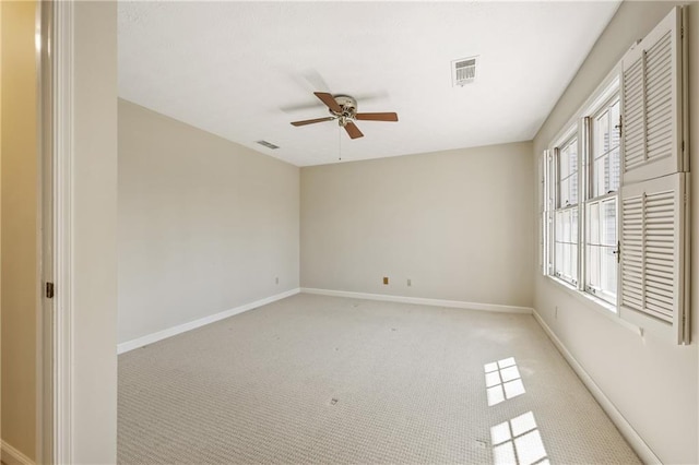 empty room featuring light carpet, baseboards, visible vents, and a ceiling fan