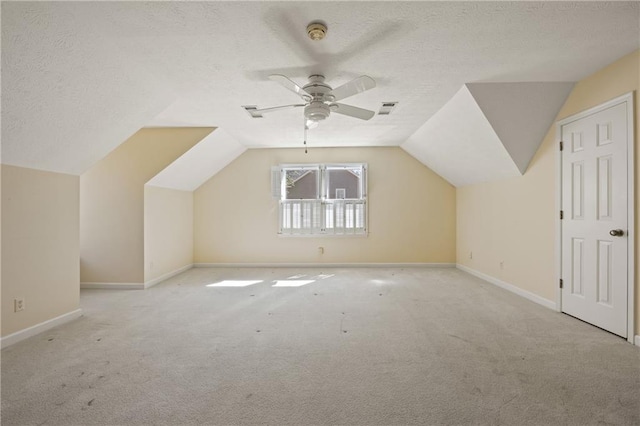 additional living space featuring lofted ceiling, baseboards, a textured ceiling, and carpet flooring