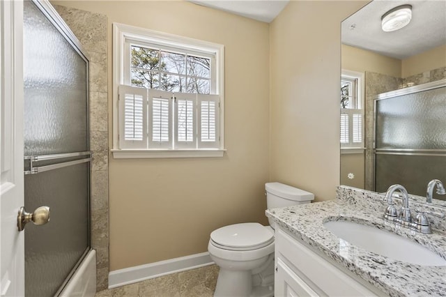 full bathroom featuring baseboards, shower / bath combination with glass door, vanity, and toilet