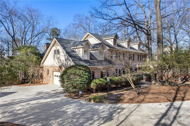 view of front facade with brick siding, driveway, and an attached garage