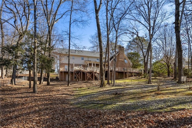 rear view of house with stairway, a chimney, and a wooden deck