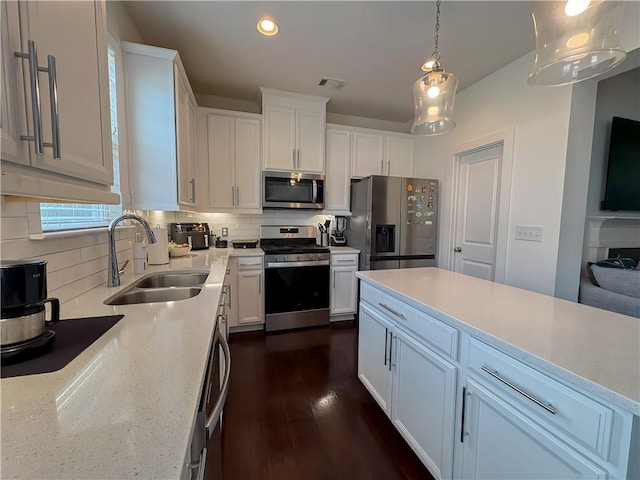 114 Garrison Dr, Winder, GA 30680 - kitchen featuring stainless steel appliances, backsplash, white cabinets, light stone countertops, and recessed lighting