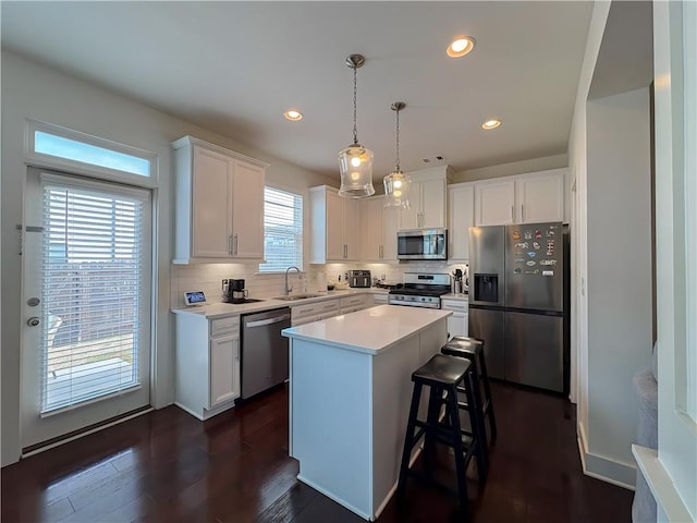 114 Garrison Dr, Winder, GA 30680 - kitchen with appliances with stainless steel finishes, white cabinets, decorative backsplash, light countertops, and dark wood-type flooring