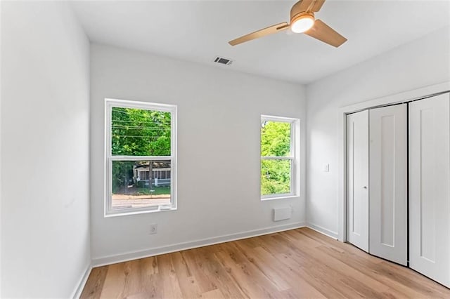 1835 Taylor Ave, East Point, GA 30344 - unfurnished bedroom with multiple windows, light wood finished floors, a closet, and a ceiling fan