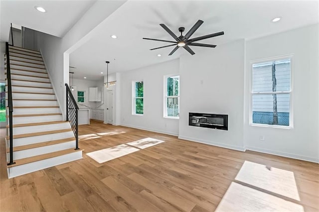 1835 Taylor Ave, East Point, GA 30344 - unfurnished living room with a ceiling fan, stairway, light wood-style floors, recessed lighting, and a glass covered fireplace