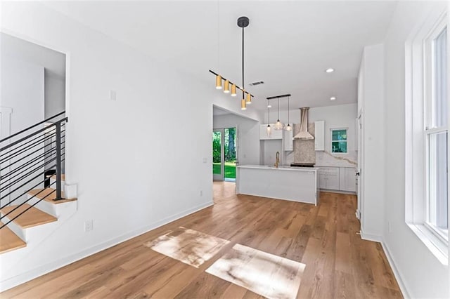 1835 Taylor Ave, East Point, GA 30344 - kitchen with wall chimney range hood, light wood-style floors, white cabinetry, decorative backsplash, and recessed lighting