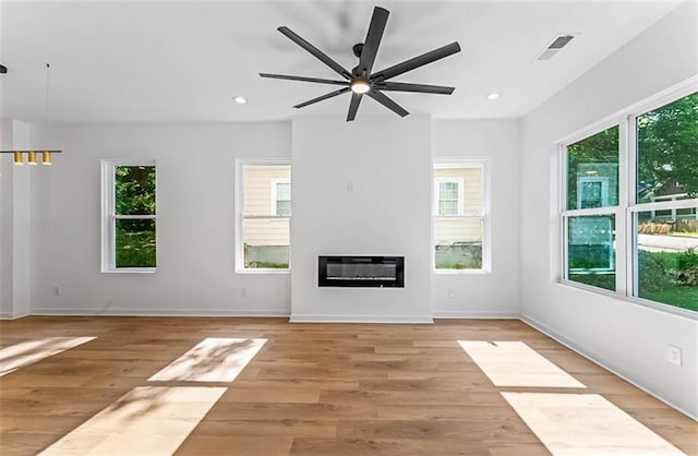 1835 Taylor Ave, East Point, GA 30344 - unfurnished living room featuring healthy amount of natural light, ceiling fan, a glass covered fireplace, light wood-style floors, and recessed lighting