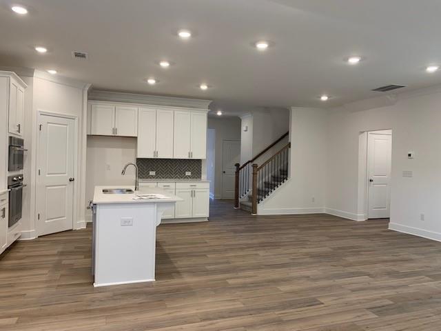 corridor with dark wood-type flooring and crown molding