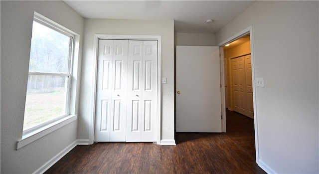 unfurnished bedroom with a closet and dark hardwood / wood-style floors