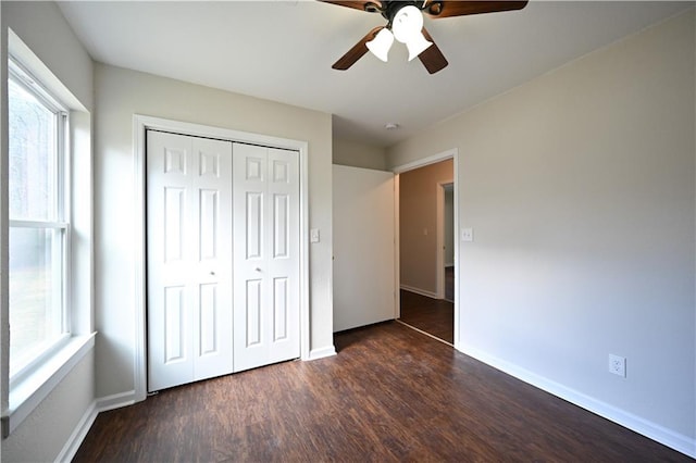 unfurnished bedroom featuring ceiling fan, dark hardwood / wood-style flooring, and a closet