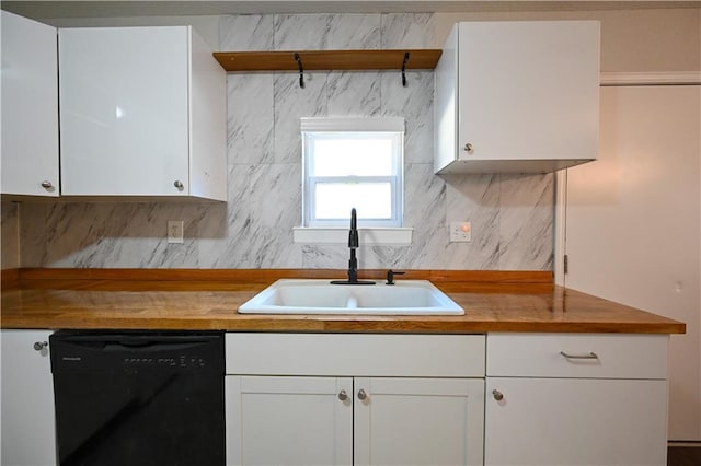 kitchen with a sink, wood counters, white cabinets, decorative backsplash, and dishwasher