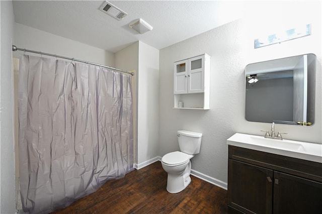 bathroom featuring a textured ceiling, vanity, ceiling fan, hardwood / wood-style flooring, and toilet