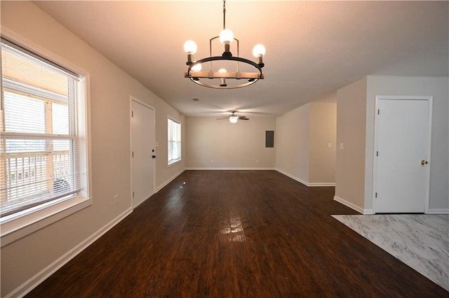 interior space with baseboards, dark wood-type flooring, and ceiling fan with notable chandelier