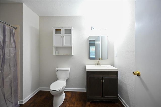 bathroom with a shower with shower curtain, vanity, a textured ceiling, wood-type flooring, and toilet