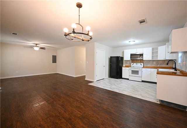 kitchen with white range with electric stovetop, stainless steel microwave, visible vents, freestanding refrigerator, and a sink