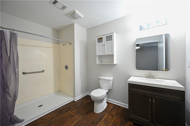 bathroom featuring hardwood / wood-style floors, vanity, curtained shower, and toilet