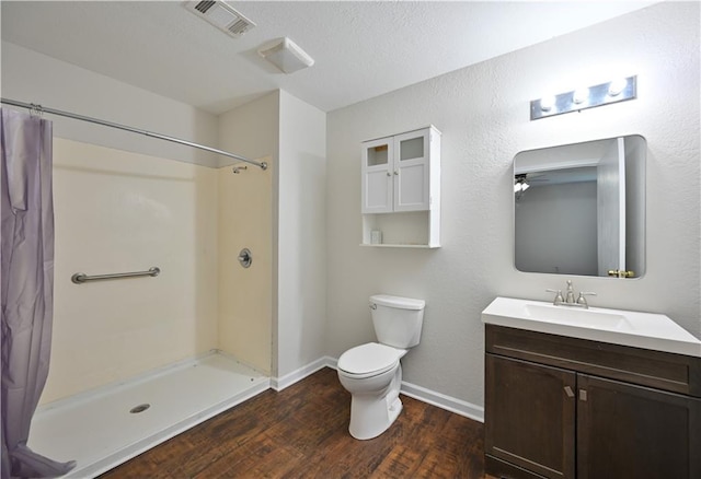 bathroom with vanity, ceiling fan, hardwood / wood-style flooring, toilet, and curtained shower