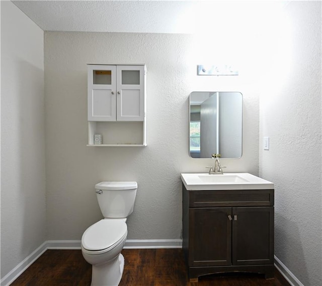 bathroom with vanity, toilet, and wood-type flooring