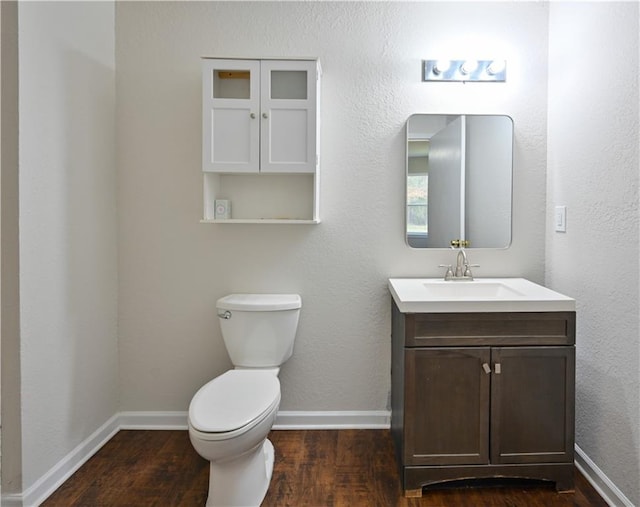 bathroom with wood-type flooring, vanity, and toilet