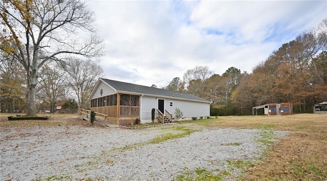 view of front of home with entry steps and a sunroom