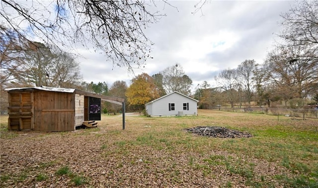 view of yard featuring an outbuilding, a carport, and fence