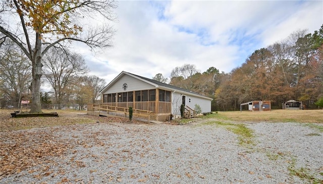 view of front of property featuring a sunroom and an outdoor structure