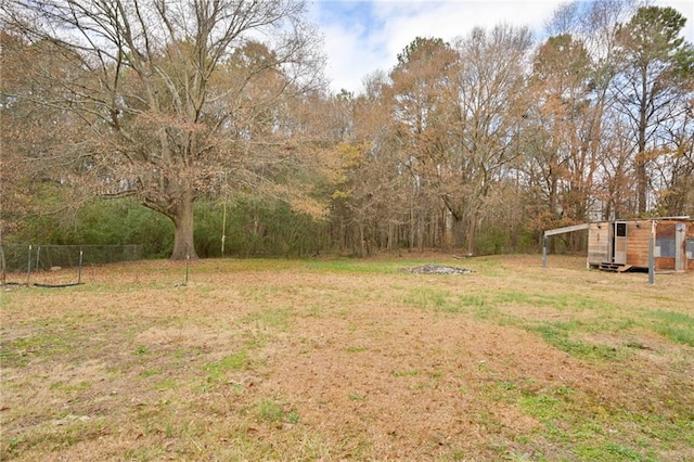 view of yard featuring an outdoor structure and fence