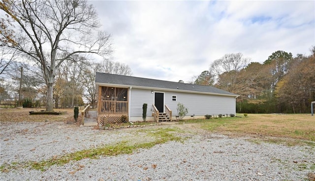 view of front of home with entry steps and a sunroom