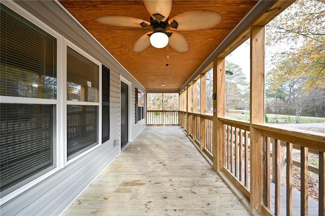 unfurnished sunroom featuring wood ceiling and ceiling fan