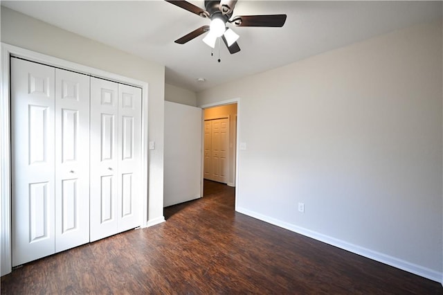 unfurnished bedroom featuring dark hardwood / wood-style flooring, ceiling fan, and a closet