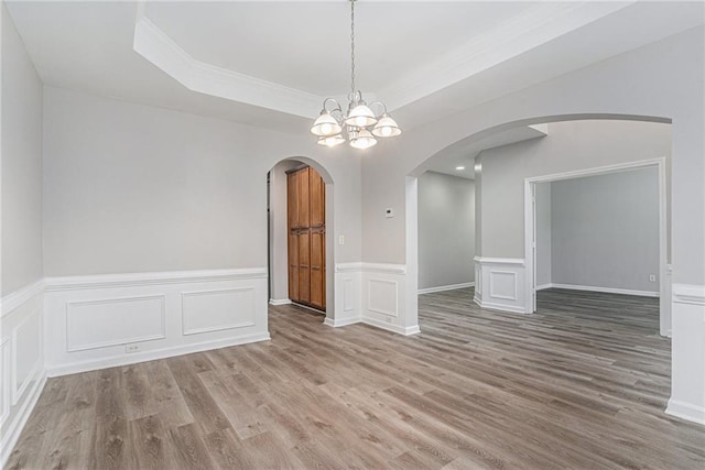 spare room featuring hardwood / wood-style floors and a notable chandelier